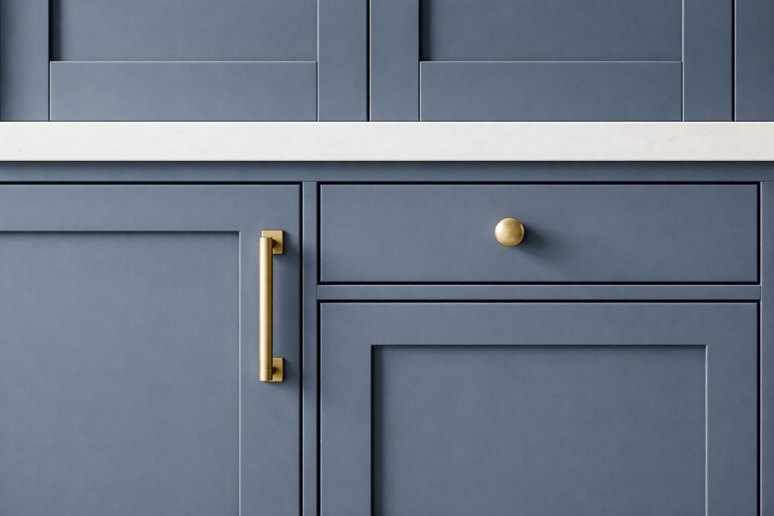 Blue-gray kitchen cabinet doors with brass and gold hardware including a pull handle and drawer knob