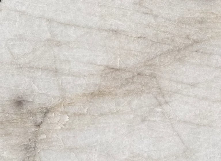 Close-up of light gray marble or stone surface with subtle veining and natural texture patterns