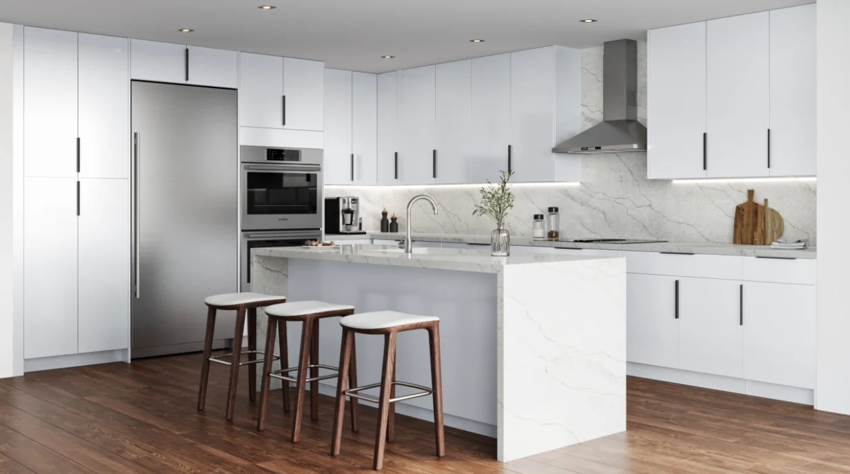 Modern white kitchen with stainless steel appliances, marble backsplash, and wooden bar stools at the island